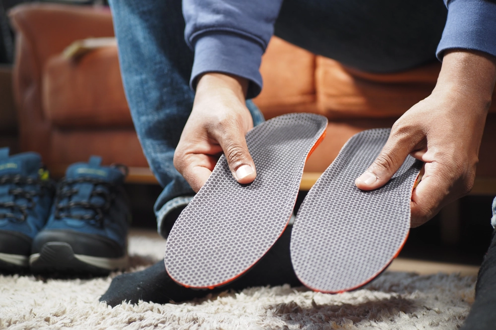 men hand putting orthopedic insoles in shoes 2024 07 09 00 37 06 utc